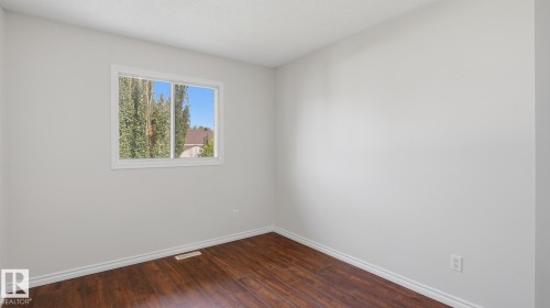 Wood-finish flooring, white trim, and a white-framed window - 12208 146 Avenue Nw, Edmonton, AB 