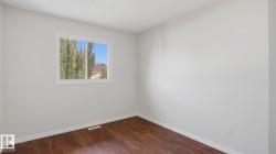 Wood-finish flooring, white trim, and a white-framed window - 
