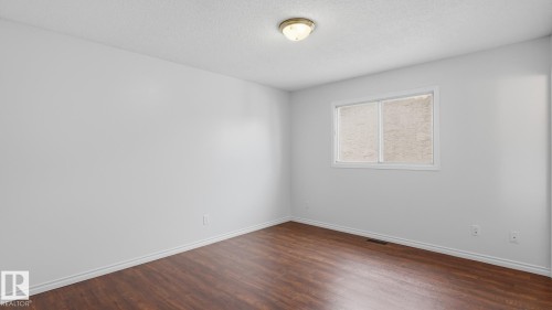 Recessed window with white trim, wood-finish flooring, and a flush-mount ceiling light - 12208 146 Avenue Nw, Edmonton, AB 