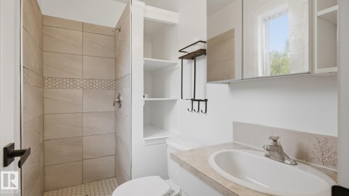 Walk-in shower with tiled surround and hex tile floor - 12208 146 Avenue Nw, Edmonton, AB 