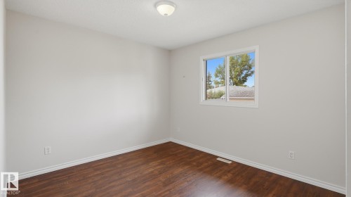 Wood-finish flooring with light-toned walls and a single window - 12208 146 Avenue Nw, Edmonton, AB 