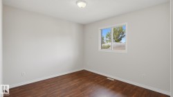 Wood-finish flooring with light-toned walls and a single window - 