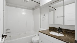 Tub-shower combination with white surround, vanity with granite-finish countertop, undermount sink, black-finish faucet, and mirrored medicine cabinet - 