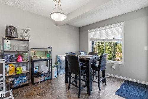 Dining area featuring a large window, tiled flooring, and neutral wall tones - 1608 65 Street Sw, Edmonton, AB - Indoor Photo Showing Dining Room