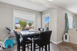 Dining area featuring a large window with blinds, a glass-paneled door, and durable tile flooring - 