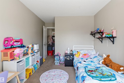 Neutral tone walls with carpeted flooring, featuring a white solid core door leading to a closet - 1608 65 Street Sw, Edmonton, AB - Indoor Photo Showing Bedroom