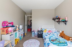 Neutral tone walls with carpeted flooring, featuring a white solid core door leading to a closet - 