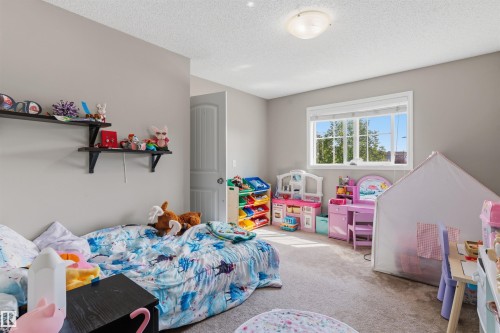 Bedroom featuring light gray walls, textured ceiling, and a flush mount light fixture - 1608 65 Street Sw, Edmonton, AB - Indoor Photo Showing Bedroom