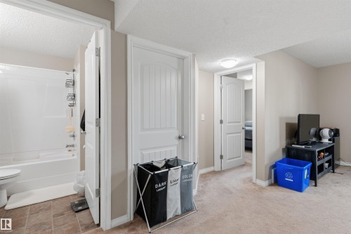 Bathroom featuring a white shower-over-tub combination with a tiled floor - 1608 65 Street Sw, Edmonton, AB - Indoor