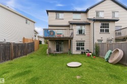 Expansive green lawn with a wood fence enclosure - 