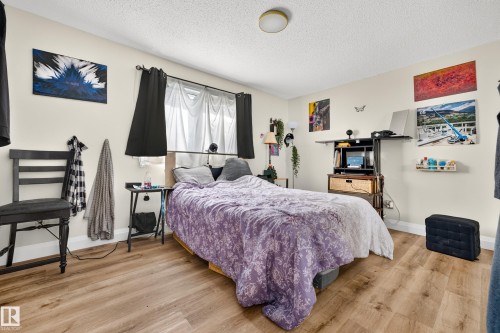 Recessed window with dark curtain rods, light-toned walls, and wood-finish flooring - 2412 80 Street Nw, Edmonton, AB 