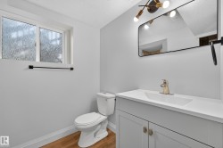 Vanity with integrated sink, gold-finish faucet, and modern light fixture - 