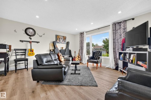 Recessed ceiling lighting, wood-finish flooring, and a large window with white trim - 2412 80 Street Nw, Edmonton, AB 