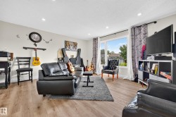 Recessed ceiling lighting, wood-finish flooring, and a large window with white trim - 