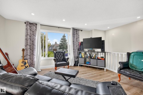 Hard-surface flooring, large window, recessed lighting, and white railing - 2412 80 Street Nw, Edmonton, AB 