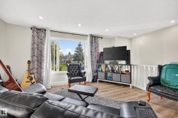 Hard-surface flooring, large window, recessed lighting, and white railing - 