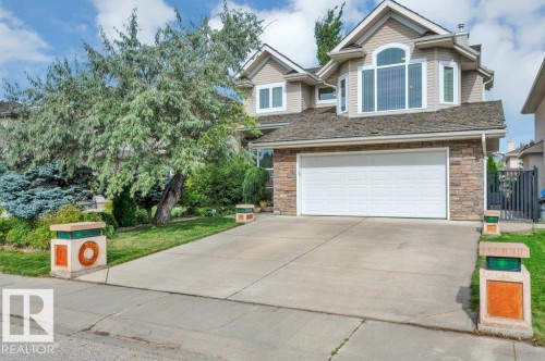 Siding exterior with stone accents, attached garage, concrete driveway, and mature landscaping - 739 Haliburton Crescent Nw, Edmonton, AB 