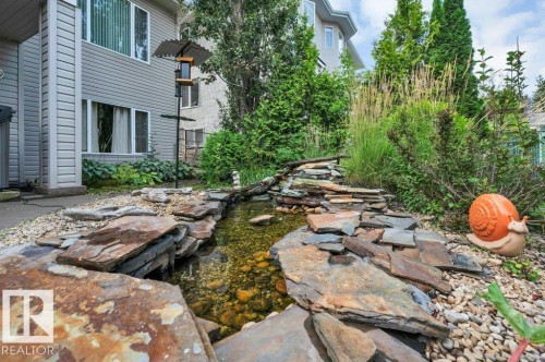 Decorative water feature with natural stone detailing and lush perimeter landscaping - 739 Haliburton Crescent Nw, Edmonton, AB 