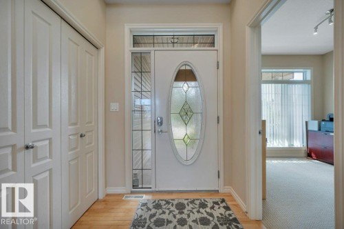Entry with hardwood flooring, a decorative glass front door, and a transom window - 739 Haliburton Crescent Nw, Edmonton, AB 