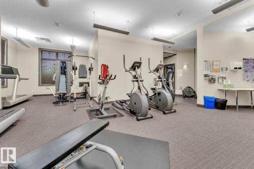 Carpeted fitness area with recessed lighting, ceiling fans, and a large window - #105 160 Magrath Rd Nw, Edmonton, AB 