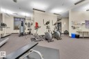 Carpeted fitness area with recessed lighting, ceiling fans, and a large window - #105 160 Magrath Rd Nw, Edmonton, AB 