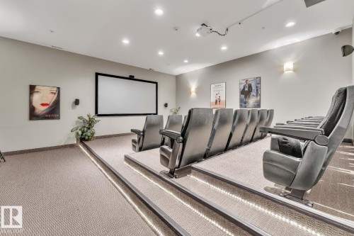 Tiered seating with integrated step lighting, large projection screen, recessed ceiling lighting, wall-mounted speakers, and wall sconces - #105 160 Magrath Rd Nw, Edmonton, AB 