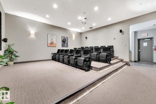 Theater-style seating, recessed ceiling lighting, wall-mounted sconces, integrated projector, and sound system speakers - #105 160 Magrath Rd Nw, Edmonton, AB 