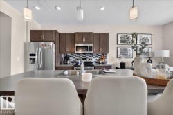 Kitchen featuring wood cabinetry, stainless steel appliances, a tile backsplash, and recessed lighting - 