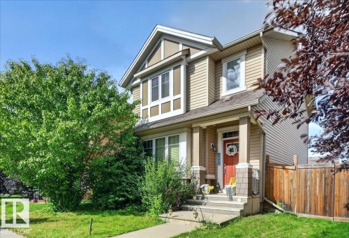 Two-story home with a gabled roofline, light-toned siding, and dark trim accents - 2046 Chalmers Way Sw, Edmonton, AB 