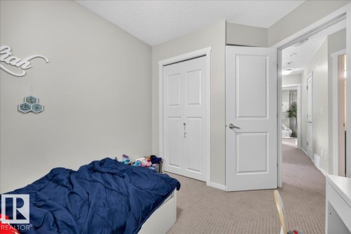 Light-colored wall finishes, contrasting trim, panel-style interior doors, and neutral carpet flooring - 2046 Chalmers Way Sw, Edmonton, AB 