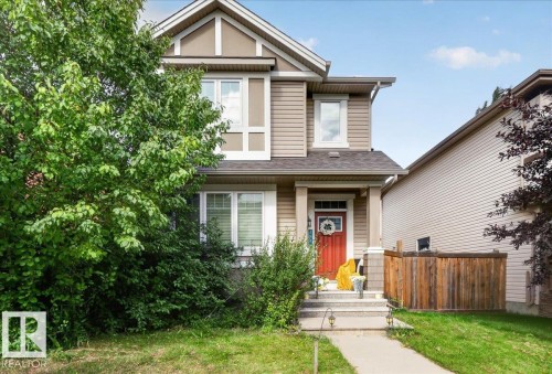 Two-story residence featuring horizontal siding, a red entry door, white trim, and a gabled roofline - 2046 Chalmers Way Sw, Edmonton, AB 