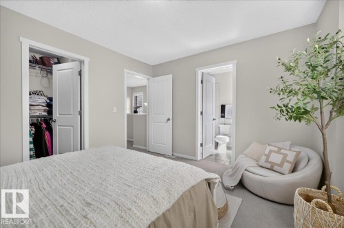 Light-colored walls, carpeted flooring, and a single-panel door with a privacy lock - 2046 Chalmers Way Sw, Edmonton, AB 
