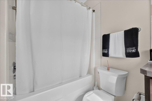 White bathtub and shower combination with a chrome shower fixture - 2046 Chalmers Way Sw, Edmonton, AB 