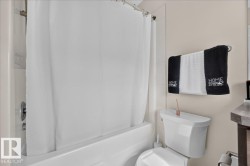 White bathtub and shower combination with a chrome shower fixture - 