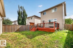 Raised wood deck with red finish, black metal railings, and wood pergola - 