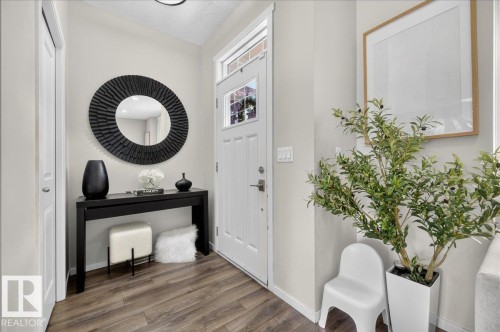 Wood-finish flooring, white paneled door with window, recessed lighting, and light-toned wall paint - 2046 Chalmers Way Sw, Edmonton, AB 