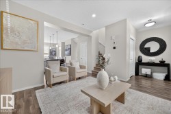 Wood-finish flooring throughout, light neutral wall tones, recessed lighting, staircase with closed risers, and built-in closet with panel door - 