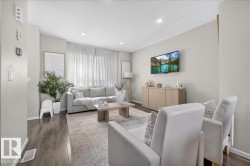 Wood-finish flooring, recessed lighting, neutral wall tones, full-height window with sheer curtains, and built-in wall controls - 
