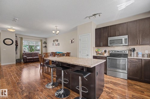 Open-concept layout featuring wood-finish flooring - 3343 Weidle Way Sw, Edmonton, AB 