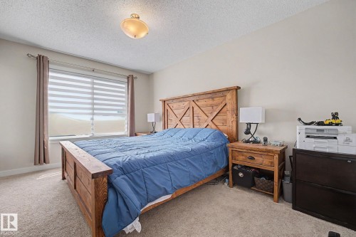 Window with horizontal blinds and drapes, light neutral wall paint, textured ceiling, and neutral carpet - 3343 Weidle Way Sw, Edmonton, AB 