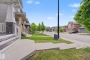 Exterior entry with wood-look steps and white railings - 3343 Weidle Way Sw, Edmonton, AB 