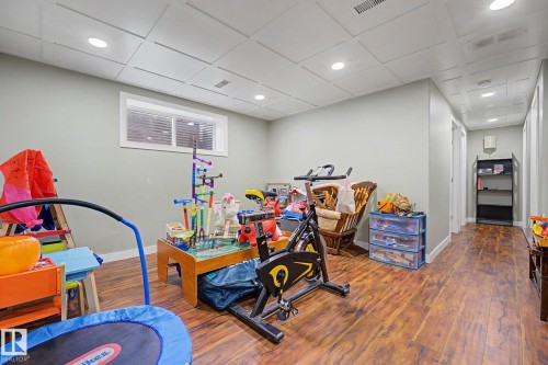 Room featuring wood-finish flooring, recessed lighting, and a drop ceiling with square paneling - 3343 Weidle Way Sw, Edmonton, AB 