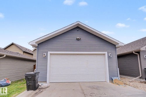 Detached garage featuring horizontal siding, a pitched roofline, and a white overhead door - 3343 Weidle Way Sw, Edmonton, AB 