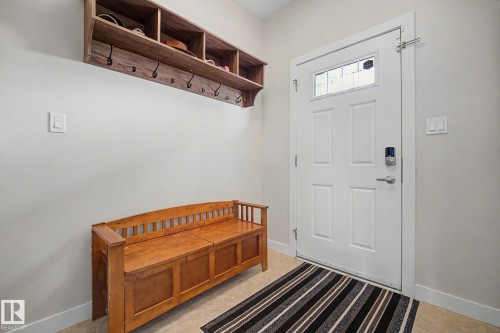 Entryway featuring a paneled white door with a transom window, durable tile flooring, and light wall paint - 3343 Weidle Way Sw, Edmonton, AB 