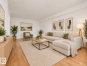 Bright living space featuring wood-finish flooring and white walls - #119 3611 145 Av Nw, Edmonton, AB 