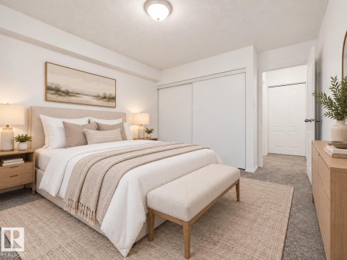 Spacious room with plush carpeting, neutral wall colors, and a ceiling-mounted light fixture - #119 3611 145 Av Nw, Edmonton, AB 