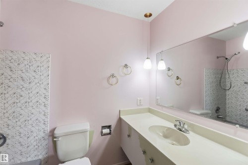 Long vanity with integrated sink, full-width mirror, and two pendant light fixtures - 9311 68 Street Nw, Edmonton, AB 