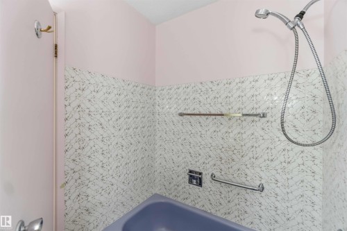 Tub/shower combination with patterned tile surround and a handheld shower fixture - 9311 68 Street Nw, Edmonton, AB 