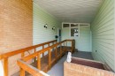 Covered entry with light green siding and brick accents - 9311 68 Street Nw, Edmonton, AB 