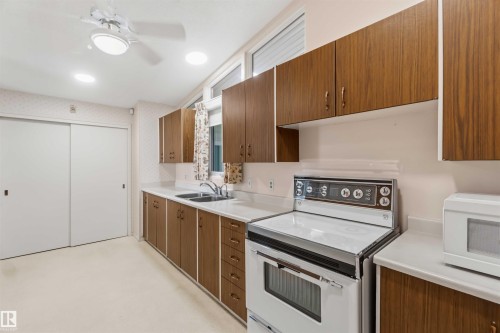 Wood-finish cabinetry paired with light countertops - 9311 68 Street Nw, Edmonton, AB 